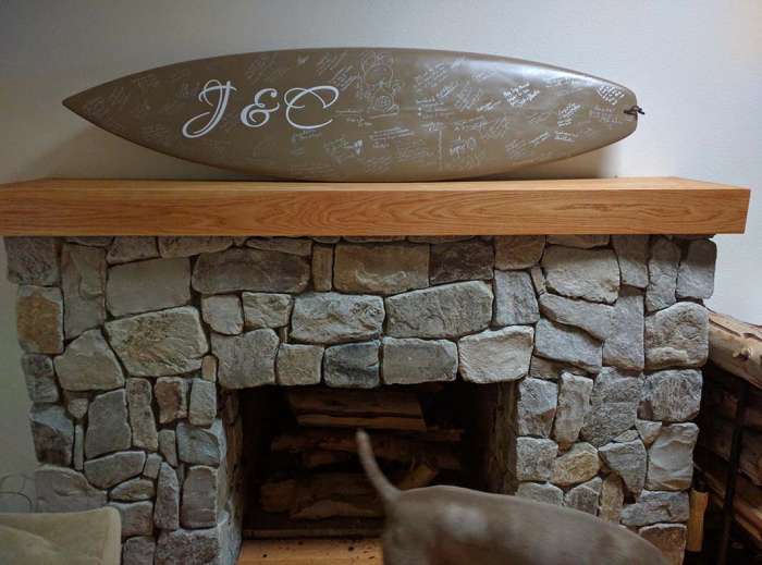 Wedding guest book surfboard on mantle